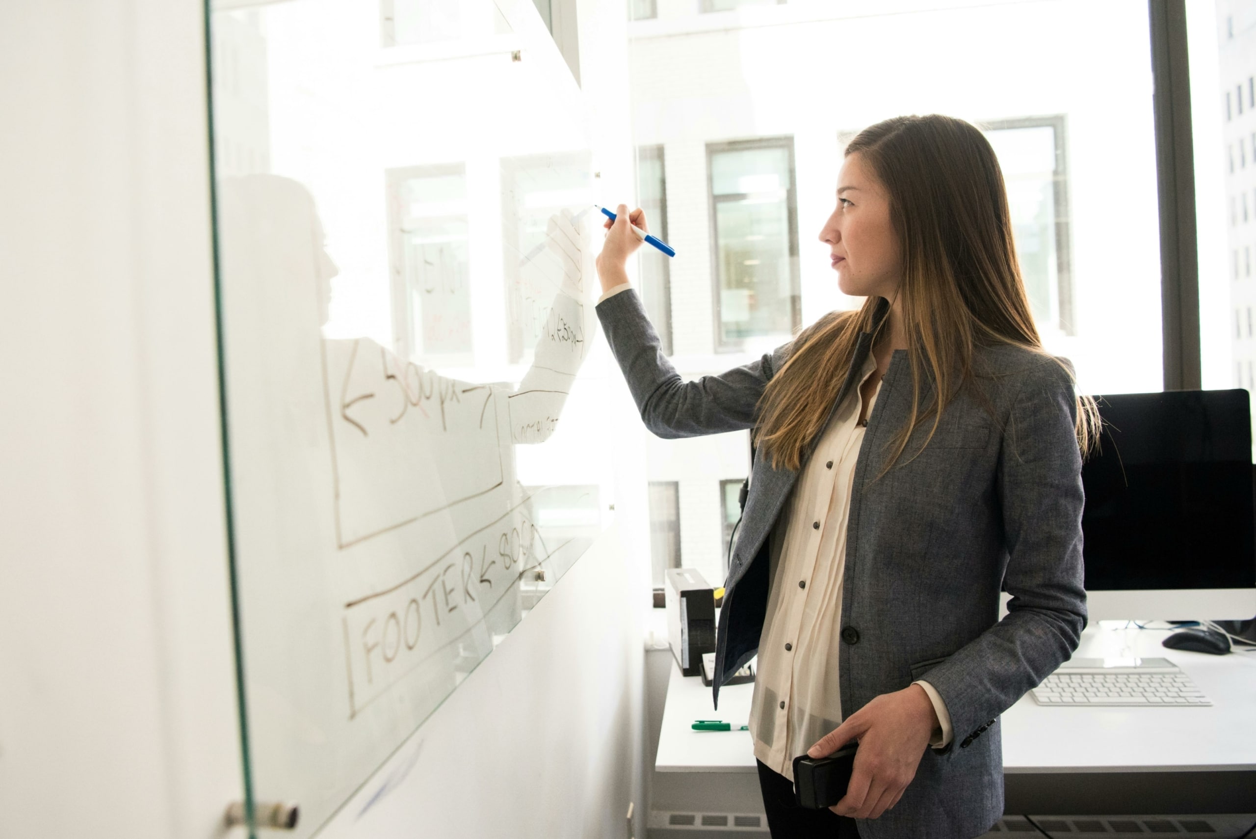 une femme qui écrit sur son tableau responsable commercial